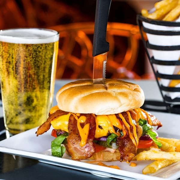 A bacon cheeseburger with fries and a beer, served at Born And Raised Centennial.