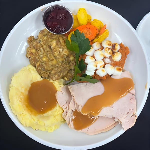 Born And Raised Centennial's Thanksgiving plate with turkey, mashed potatoes, stuffing, sweet potatoes, and cranberry sauce.