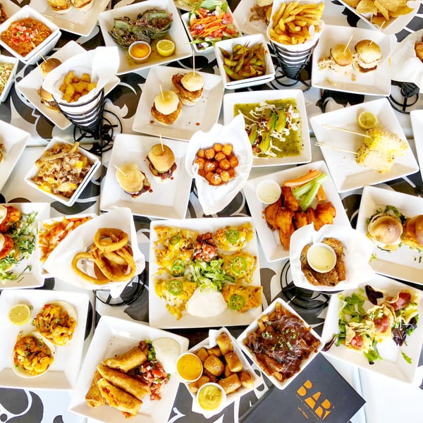 An overhead view of a table covered with various appetizers and small plates from Born And Raised Centennial.